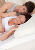 adorable young future parents sleeping on the bed during the mor