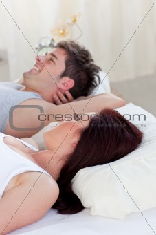 portrait of a happy man lying on the bed with his pregnant woman