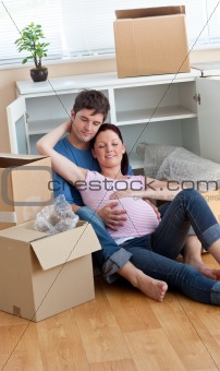 future parents relaxing on the floor during a break after unpack