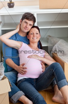 portrait of future parents in their new home sitting in their ne
