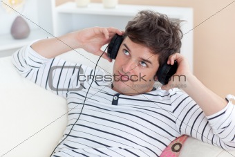 thoughful man listening music looking the top sitting in the sof