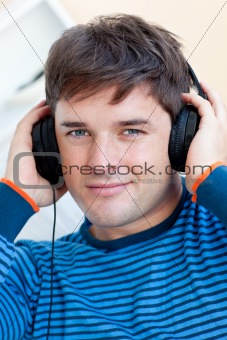 peaceful man listening music using headphones smiling at the cam