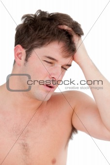 portrait of a young man having a painful headache during the mor