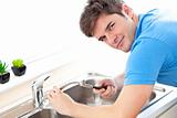 Assertive man repairing his sink