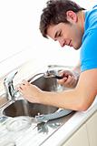 Caucasian man repairing a kitchen sink at home