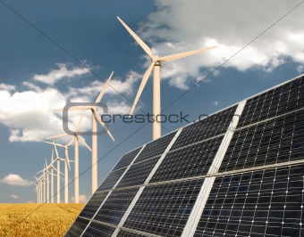 Solar panels in front of wind energy plants and wheat field