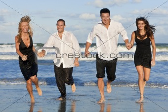 Four Young People, Two Couples, Having Fun Running On Beach