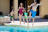 Family With Two Children Having Fun Jumping Into Swimming Pool