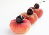 Peaches and cherries on white background