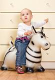 Beautiful Baby Girl on a toy Horse