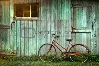 Old bicycle leaning against grungy barn