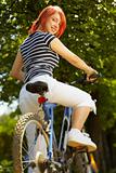 young adult smiling biker woman on mounting bike 