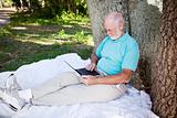Senior Man in Park With Computer