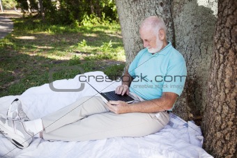 Senior Man in Park With Computer