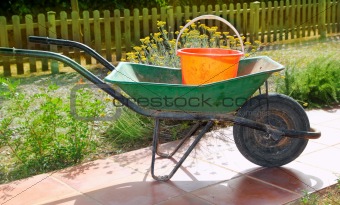 gardener green wheel barrow with orange pail