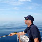 Sailor man sailing boat blue calm ocean water