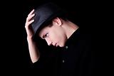 Young man wearing a hat over black background, studio shot