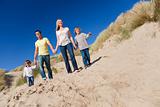 Mother, Father and Two Boys Walking Having Fun At Beach