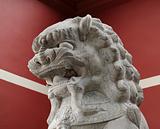 stone lion statue before the red wall