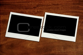 two empty polaroids on wooden background