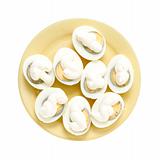 Eggs under mayonnaise on a yellow plate