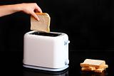 Hand putting bread to toaster