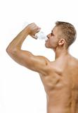 Handsome muscular male drinking water