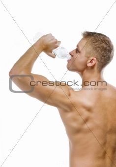 Handsome muscular male drinking water