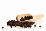 black peppercorns with a small wooden shovel side