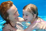 Pool mother and daughter playing together swimming