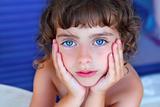 Beautiful blue eyes little girl portrait hands on face