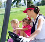 golf course family mother and daughters in buggy