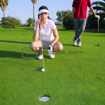 golf young woman looking and aiming the hole