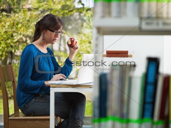 girl holding apple in library