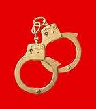 golden handcuffs isolated on red background