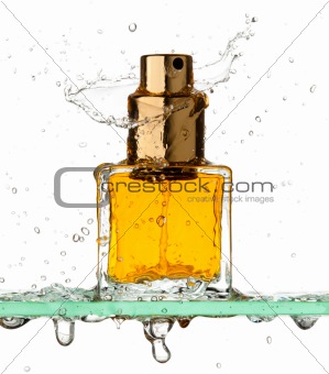 Bottle of perfume in a spray of water