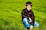 Little boy sitting on the grass