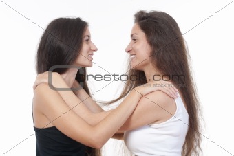 two sisters with long brown hair embracing each other, smiling