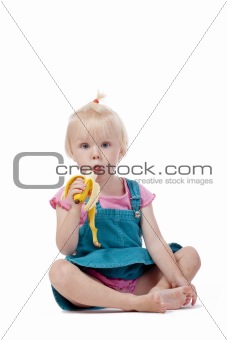 portrait of a little girl with blond hair eating banana - isolated on white