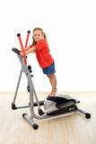Little girl standing on top of elliptical trainer