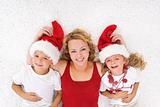 Woman and kids lating on the floor at christmas time