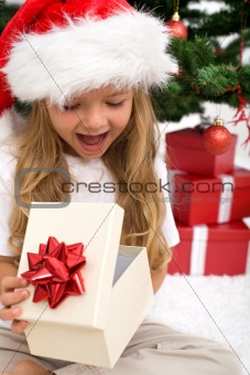Excited little girl opening christmas present