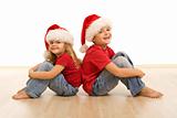 Happy kids on the floor wearing christmas hats