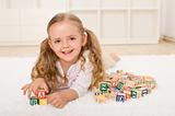 Little girl with alphabet wooden blocks playing