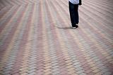 Person walking on tiled pedestrian road