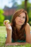 Beautiful Woman Outside Eating An Apple and Thinking