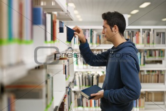 man choosing book in library