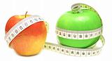 tape measure wrapped around green and red apple