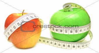 tape measure wrapped around green and red apple