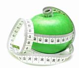 tape measure wrapped around green apple